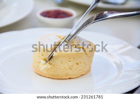 Close up of delicious scone cutting with knife and spoon for serving