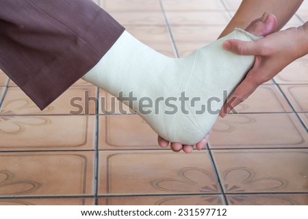 Close up of broken ankle/leg being nursed by a lady for medical background