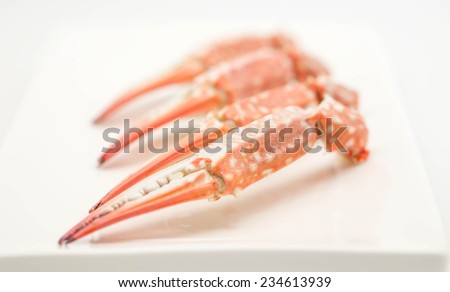 Close up of freshly steamed crabs with sweet taste on white ceramic plate for seafood cuisine background