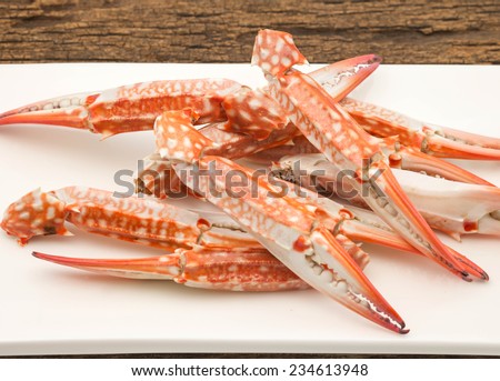 Freshly cooked crabs on white ceramic plate on wood table for seafood background