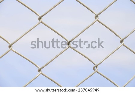 Close up of metal fence for barrier or boundary against blue sky background