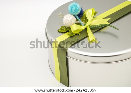 Close up of silver rounded box full of fresh baked cookies or bakery for giving as present for holiday season on white background