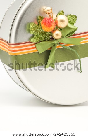 Close up of silver rounded box full of fresh baked cookies or bakery for giving as present for holiday season on white background