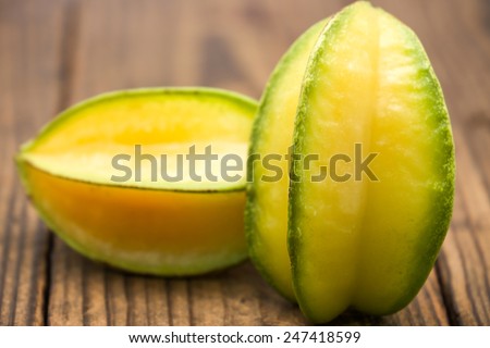 Sweet and sour star fruits or carambola on brown wood for tropical food background
