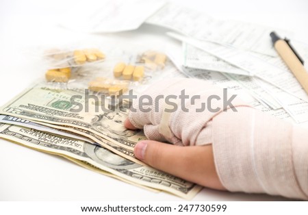 Medical expense with broken or splint hand with us dollars currency, bills and pen on white background