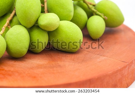Isolated fresh and green mangoes with green leafs on wood, tropical fruit with sour taste for food background