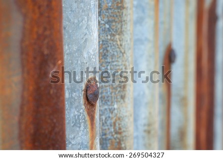Close up of rustic nail on old metal plate for barrier background