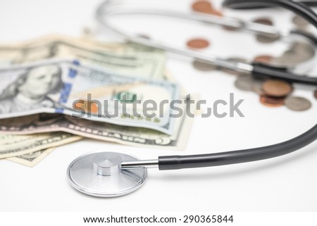 US banknotes or bills and coins with stethoscope for medical expense background
