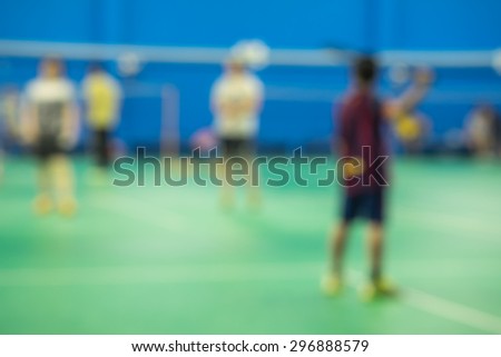 De focused or blurred players on badminton court for sport activity background