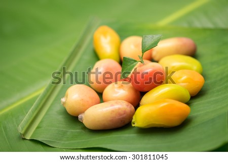 Fresh and delicious colorful bean in fruit shape on green banana leaf for local Thai dessert background