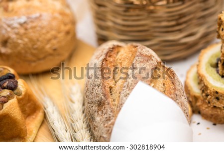 Fresh whole grain wheat bread and loaf on wooden cutting board for healthy diet background