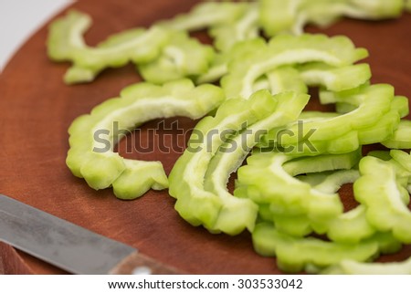 Fresh and green bitter gourd on wooden cutting board for food ingredient background