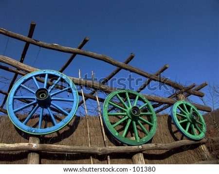 Three hanging colored cart wheels