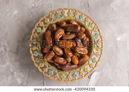 An ornamental bowl of Arabian dates. Top view.