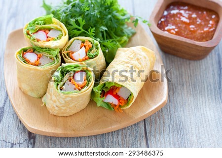 Vegetarian food,Homemade egg rolls and Sweet chili sauce on wood table