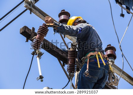 Bangkok, Thailand - May 16, 2015: Electrician working on the electricity pole to replace the electrical insulator