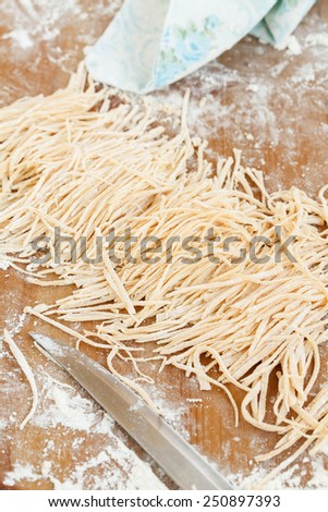 Fresh Homemade Pasta Dough Recipe on Table Filled with Flour and Wooden Roller on Side. Handmade ribbon pasta. Step on step. See series. Rustic style
