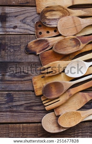 Still life with old wooden kitchen accessories, onions and bread onto an vintage surface. Kitchen wooden utensil of scapula, spoon and fork on wooden table. Natural old food concept . Top view.