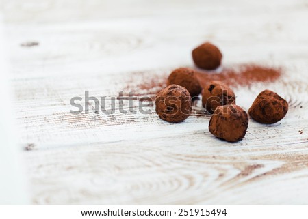 Homemade natural chocolate truffle with cacao on white wooden background. Rustic style.