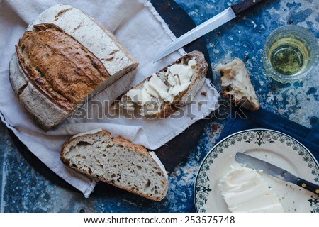 Freshly baked delicious crusty wholewheat seed bread with butter served on a rustic cloth  in a country kitchen with a vintage kitchen accessories. Healthy food concept.