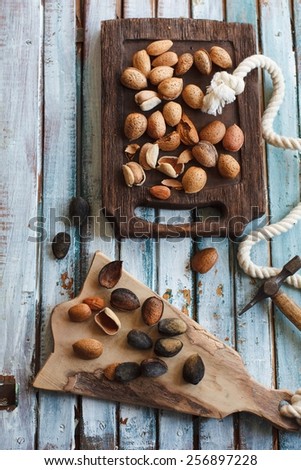 Still life with almonds on hard-shelled onto a vintage background. Concept image for healthy, diet or vegetarian cooking. Natural fruit of garden. Rustic style. Top view.