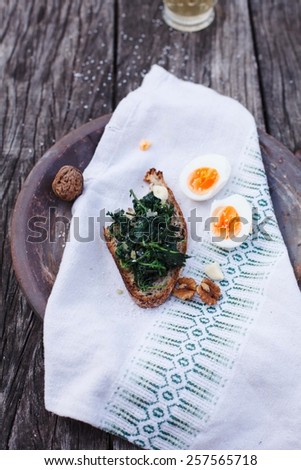 Freshly Nettles with egg in a old ceramic plate over old wood table. Natural and vegetarian  food of garden. Rustic style. Top view.