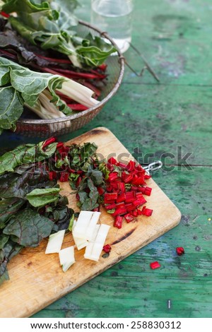 Swiss chard or leafs´beet over on wooden table ,  taken on vintage kitchen green table. Vegetarian and natural food concept. Healthy vegetables from garden. See series.