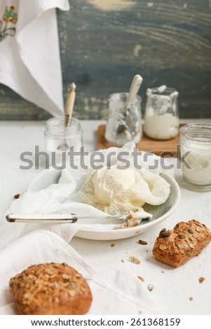 Whole bread with making cream cheese and jars of yogurt taken on vintage white kitchen counter preparing for breakfast. Healthy and diet food concept. Rustic style. See series. Top view.