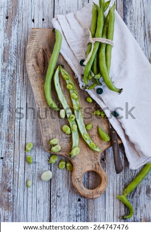 Fresh and organic vegetables of garden. Green string beans over a napkin texture, on a vintage wood table. Top view. Rustic style