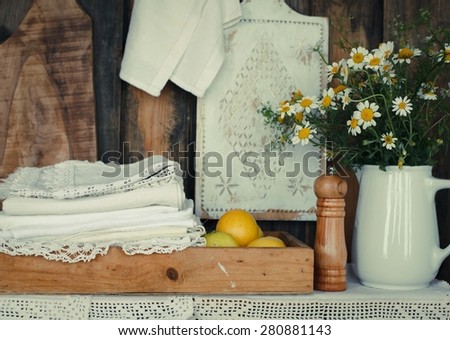 Rustic image with vintage linen embroidery and summer chamomile flower. Toned image.