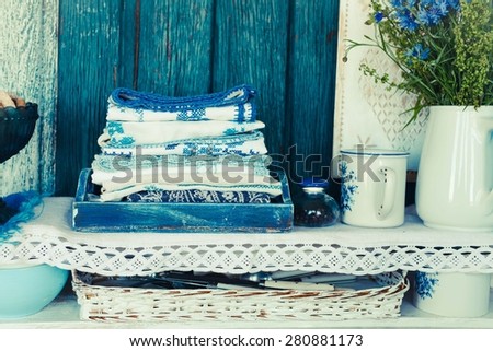 Various linen traditional canvas with blue embroidery from above kitchen shelves. Rustic style.Toned image.
