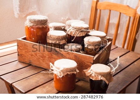 Picture of home made jam  in jars. Homemade preserves (conserve) concept in country kitchen. Rustic style.