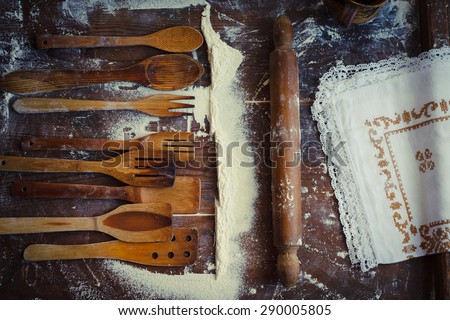 Assortment of traditional rustic kitchen utensils with rolling pin and rustic embroidery cloth situated from above vintage kitchen wooden table. Country, homemade and real food concept. Rustic style.
