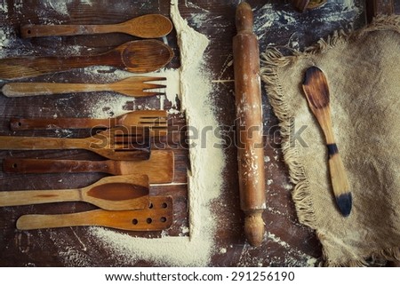 Creative country food concept. Retro image with vintage kitchen wooden utensils and sack cloth from above. Rustic style. Toned image.