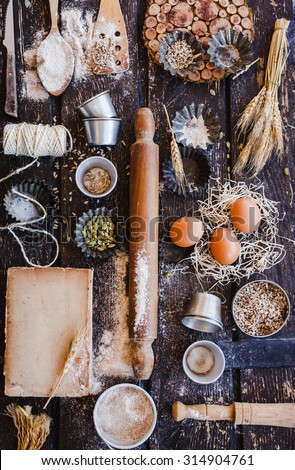 Baking and pastries vintage concept. Various vintage kitchen utensils, props and ingredients from above on a rustic dark wooden table with flour, seeds and old book copy space. Rustic dark.\
Copy space