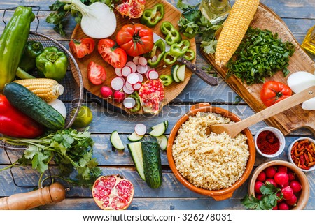 Typically middle eastern food. Various fresh vegetables on a blue wooden table  and cook burghul in ceramic bowl ready to prepare arabian traditional food. Country food concept from above. Series.
