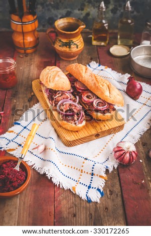 Making Chopping pork meat sandwich with pickled red onion and beet dip, pestle sauce on a wooden country chalkboard. Rustic style.