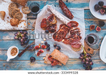 Antipasti and fruit concept. Tasting gourmet party on a rustic wooden table. A quick and easy snack for party time. Rustic style.