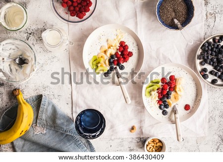 Acai coconut bowl concept. Detox and healthy breakfast bowl. Coconut milk chia seed pudding bowl with chia seeds and blueberry, raspberries, banana sliced on a top, flat lay. country style.