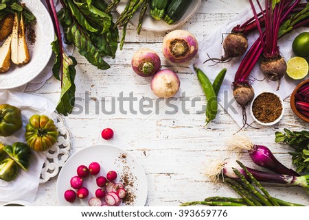 Purple and green veggies and roots composition on a rustic white wooden table. Beetroot, red onion, radish, asparagus, green tomatoes, parsnip, parsley ready to prepare salad. detox and diet food.
