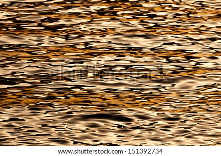 Sea water wave texture with reflection  in a gold sunset