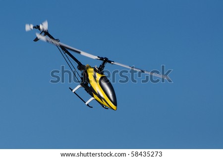 a model helicopter in flight, blue sky background