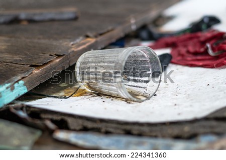 dirty glass cup lying on wooden boards close to other things