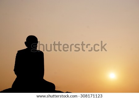 Thai monk statue in meditation with the sunrise