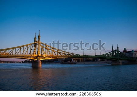 Liberty Bridge (Hungarian: Szabadsag Hid) (Ferencz Jozsef Hid) over Danube river and cityscape of Budapest in Hungary, sun reflections on bridge