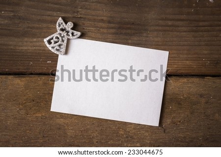 Simple greeting card for holidays with an angel ornament on wooden background