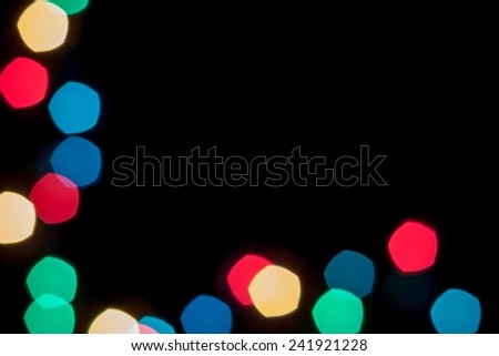 Color bokeh lights frame on two sides, on black background