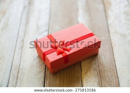 Small red gift box on wooden table