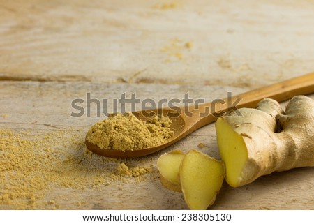 powder ginger spice and fresh ginger on a wooden background