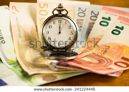 time is money concept with euros and a pocket watch